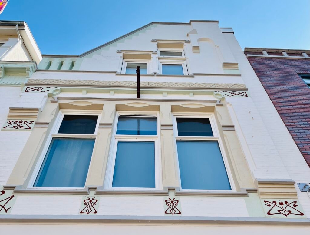 Volledig geschilderde karakteristieke binnenstadsgevel met horeca op de begane grond, inclusief kozijnen en ornamentherstel – uitgevoerd door LenKraft