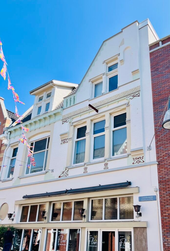 Gerestaureerde monumentale gevel met sierlijsten, zachtgroene accenten en handgeschilderde bordeauxrode ornamenten – schilderwerk door LenKraft