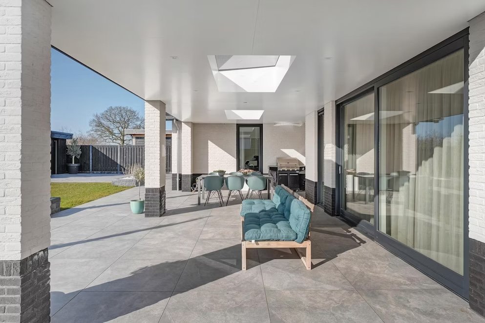 Overdekte veranda met strak afgewerkte gevel en gelakt houtwerk, uitgevoerd door LenKraft bij een nieuwbouwwoning in Twente